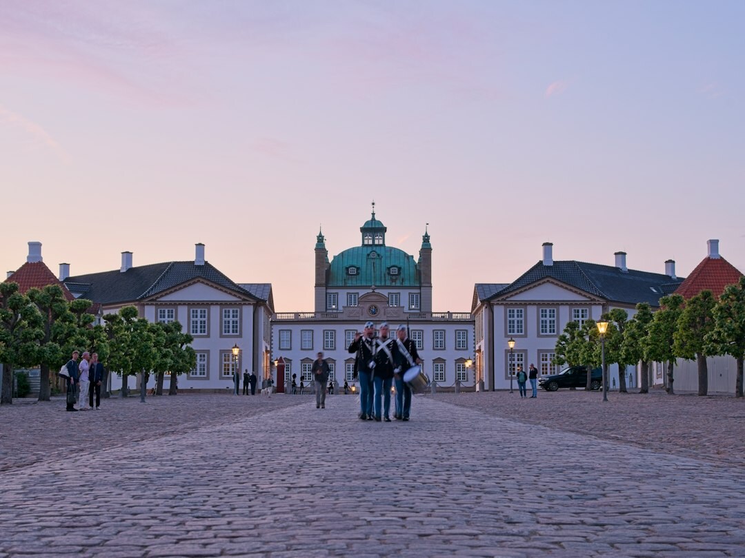 Moody black and white photo of a Danish apartment courtyard at dusk with silhouettes of people