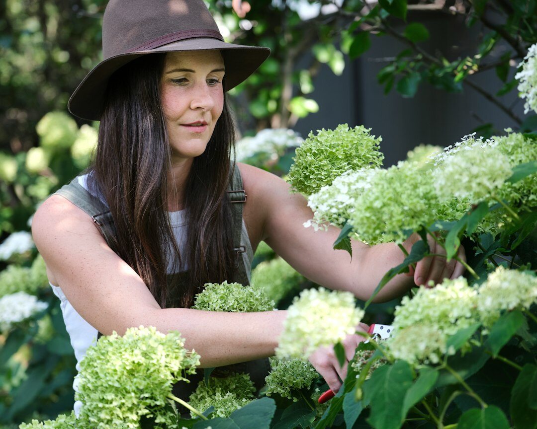 woman in garden touching flowers